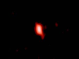 Esta imagen muestra la galaxia muy distante MACS1149-JD1, vista tal y como era hace 13.300 millones de años y observada con ALMA. / ALMA (ESO/NAOJ/NRAO), Hashimoto et al.